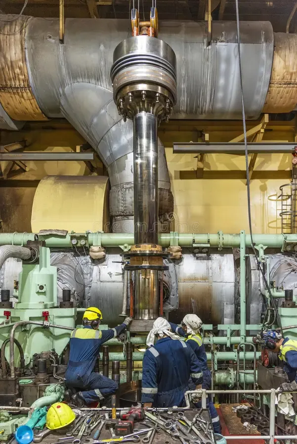 Engineers working among machinery in a ship's engine room