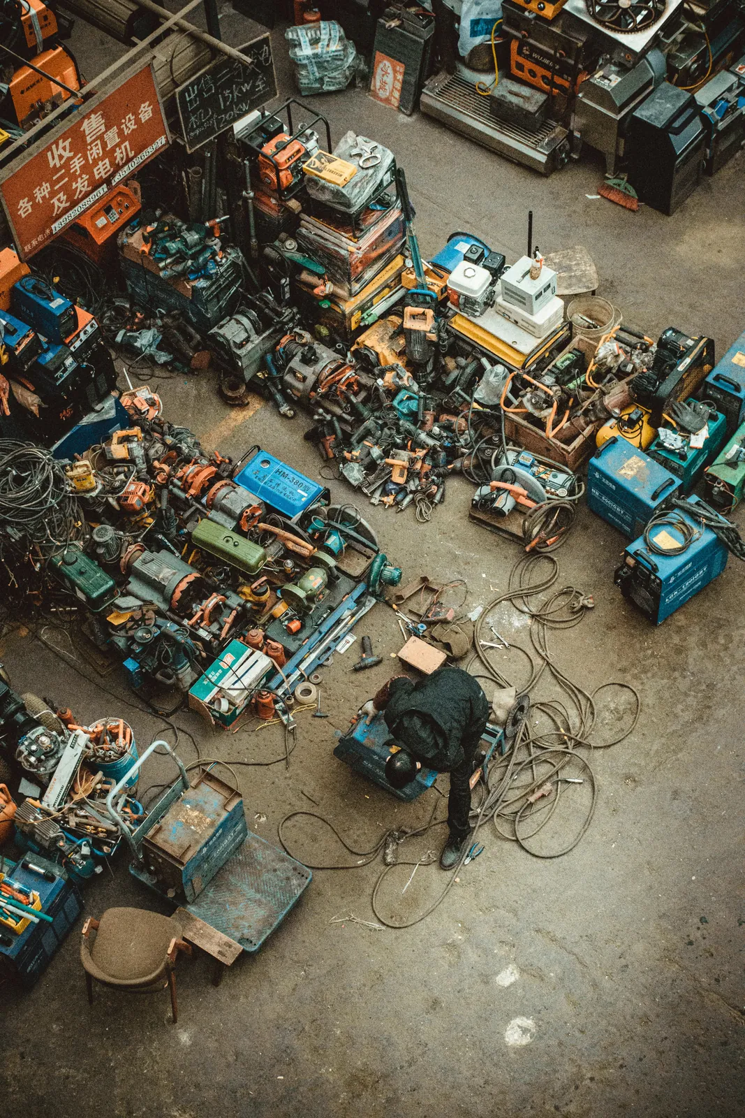 Overhead view of a welding workshop with equipment and a worker